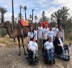Group photo of Emily Munson with tour group and camels in Morocco